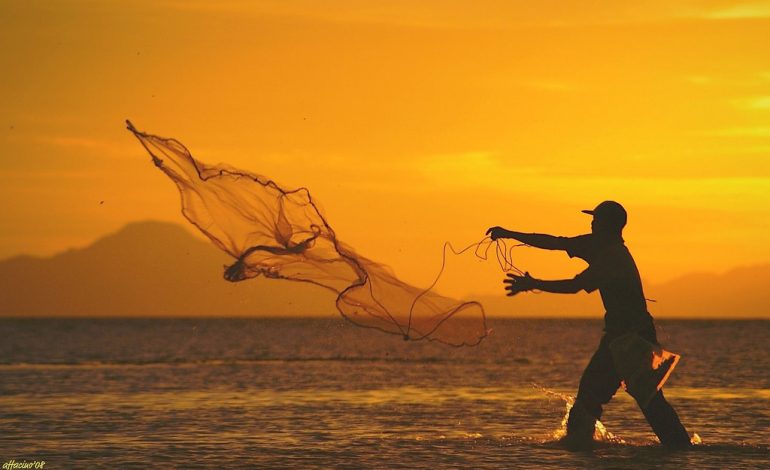 Cuaca ekstrem nelayan Medan jala ikan di tepi pantai